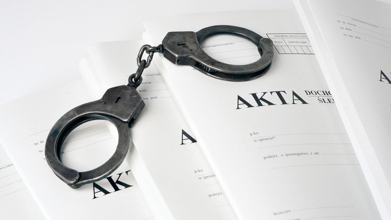Akta śledztwa i kajdanki