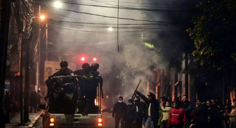 People gesture at policemen in La Paz, Bolivia on November 11, 2019 after president Evo Morales announced his resignation