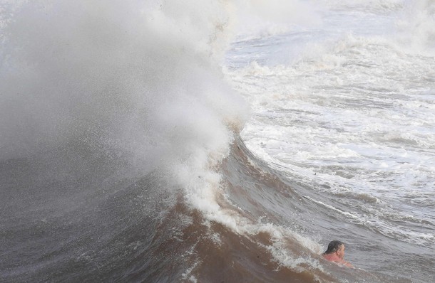 A man swims in heavy seas and high winds in Dawlish in south west Britain