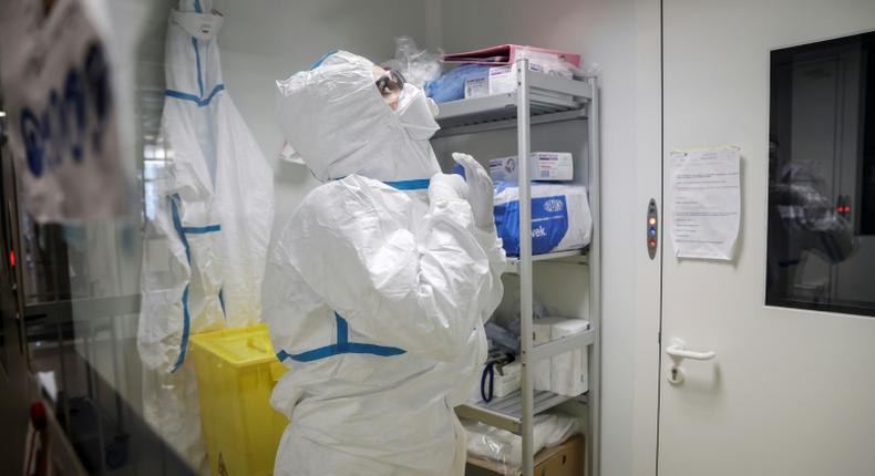 A laboratory operator puts on protective gear before handling patients' samples at the Institute Pasteur in Paris (AFP)