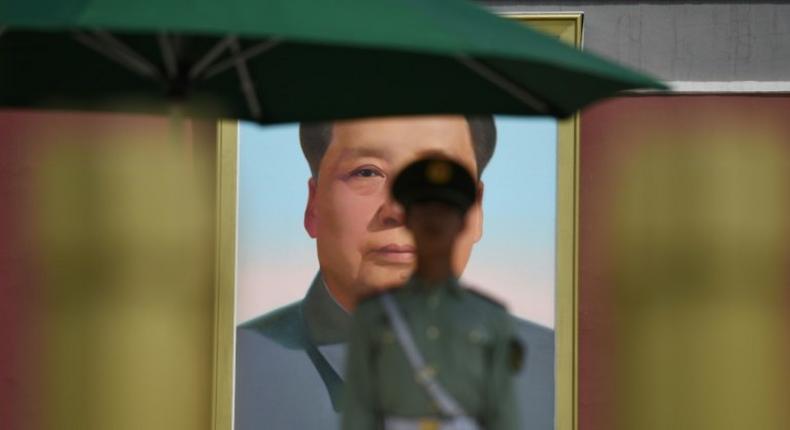 A paramilitary police officer stands guard in front of the portrait of Mao Zedong in Tiananmen Square. Flamboyant real estate tycoon Guo Wengui is waging a one-man guerrilla war against China's elite with explosive accusations of corruption