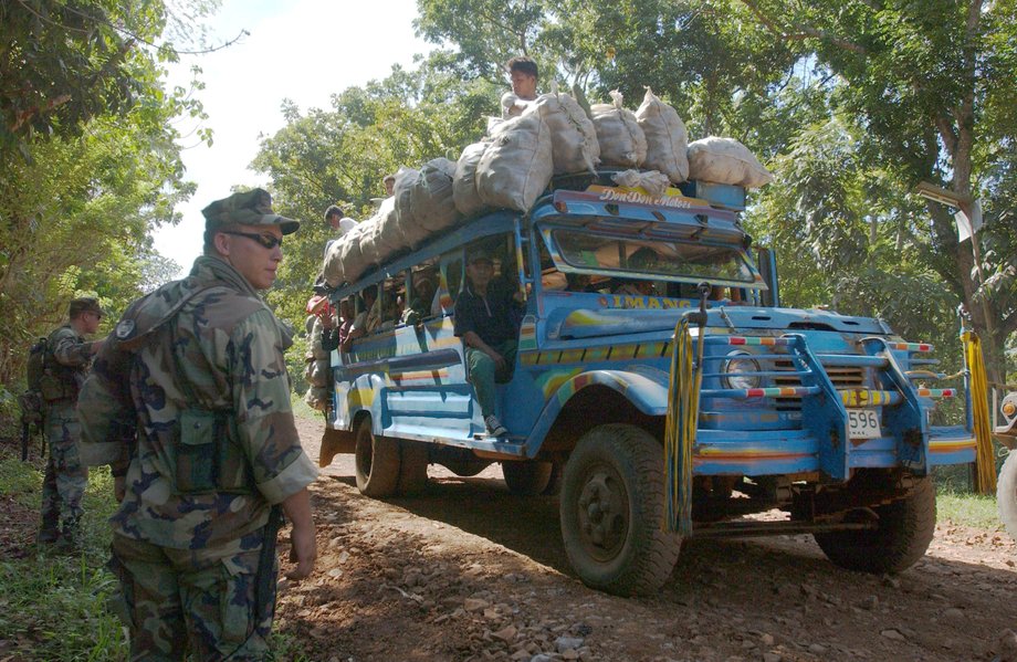 A US Marine stands guard as a truck passes on April 29, 2002, in the Philippines.