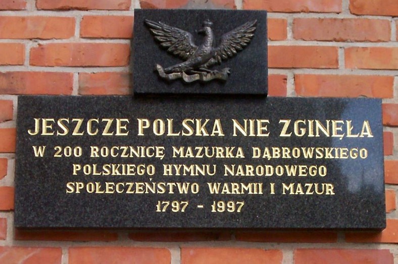 Hymn Polski związany jest z dwoma masonami: Józefem Wybickim , autorem tekstu, i Henrykiem Dąbrowskim, który pojawia się już w tytule. Na zdjęciu tablica pamiątkowa z Olsztyna.