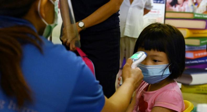 A young pupil has her temperature checked on the first day schools resumed in Singapore following the easing of some coronavirus restrictions