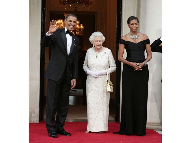 Michelle Obama wraz z mężem wita królową w londyńskiej rezydencji amerykańskiego ambasadora. Wcięta w talii czarna suknia odsłaniała nagie ramiona i dekolt, a całości towarzyszył strojny naszyjnik. Obama już dawno przełamała dyplomatyczne tabu zabraniające odsłaniania nagiego ciała i noszenia wyrazistej biżuterii