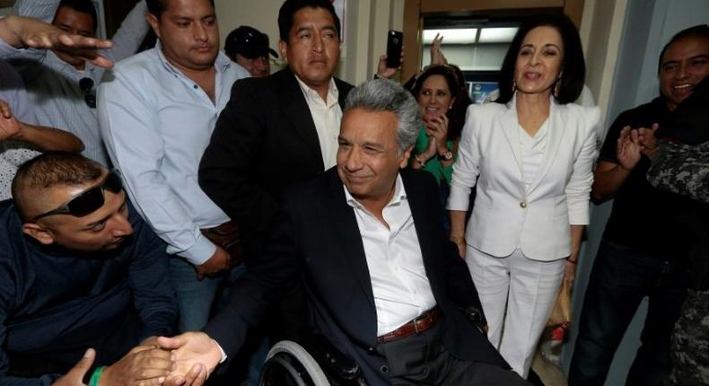The Ecuadorean presidential candidate of the Alianza PAIS party, Lenin Moreno, accompanied by his wife Rocio Gonzalez (in white), arrives at a polling station in Quito on February 19, 2017 to vote during general election