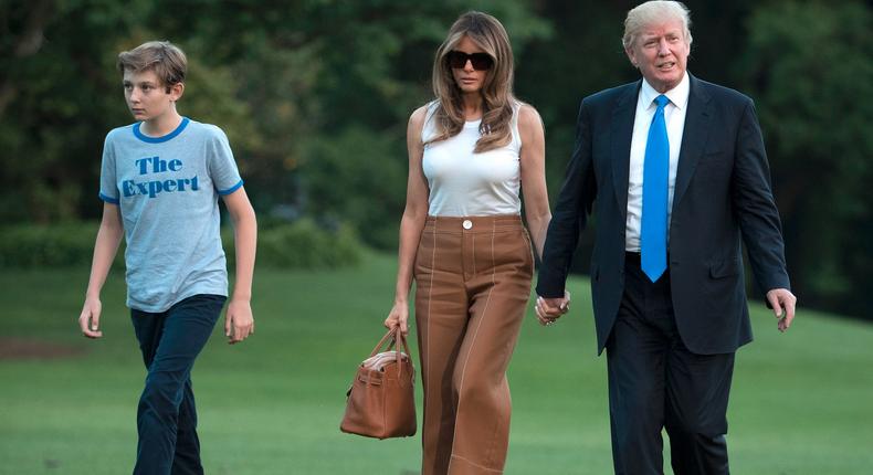 President Donald Trump, first lady Melania Trump, and their son, Barron Trump, walk from Marine One across the South Lawn to the White House.