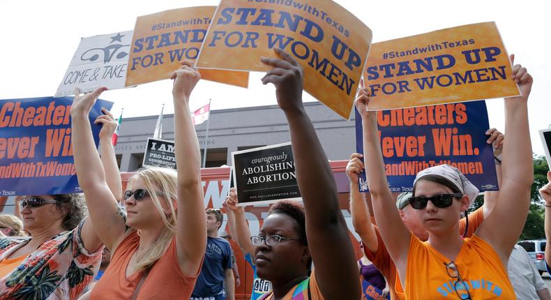 Opponents and supporters of an abortion bill hold signs near a news conference outside the Texas Capitol, in Austin, Texas.
