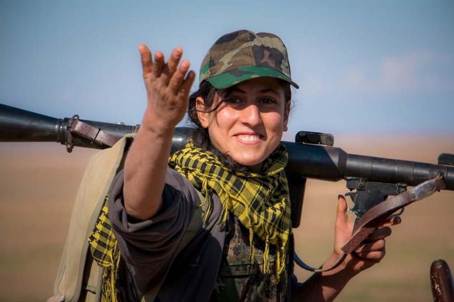 A Kurdish female fighter from the YPG gestures as she carries her weapon near the al-Hawl area where fighting between Islamic State fighters and fighters from Democratic Forces of Syria are taking place in south-eastern city of Hasaka