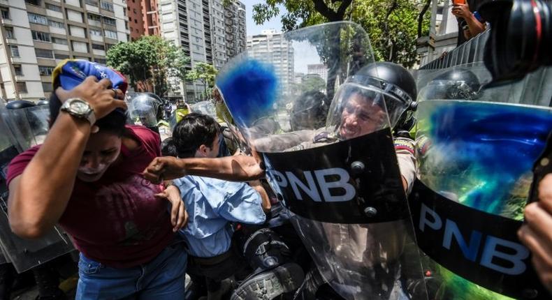 An estimated 1,000 people scuffled with police as they tried to march to Venezuela's National Assembly to demand the government restore powers to its opposition majority