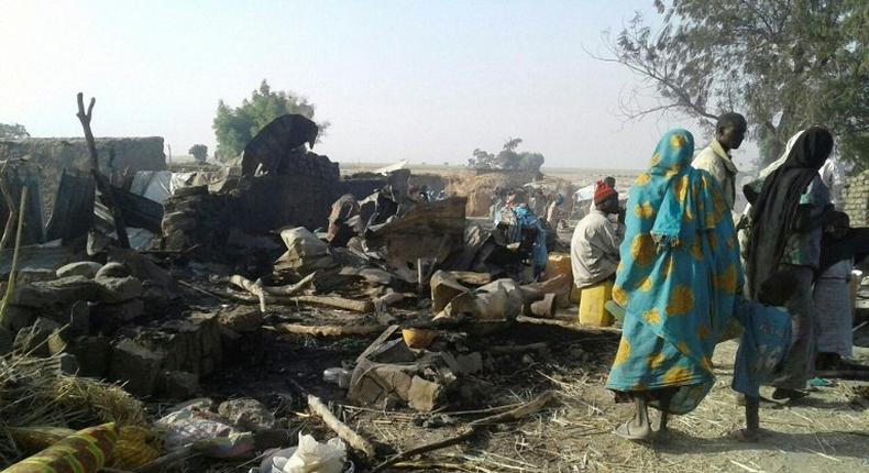 Survivors look at the aftermath of the bombing by the Nigerian air force of a camp for displaced people in Rann, northeast Nigeria, on January 17, 2017