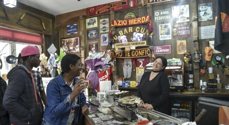 Migrants from Senegal and Niger joke with the waitress in the main bar of Sant' Alessio in Aspromonte, a small village of 330 inhabitants in Calabria, southern Italy