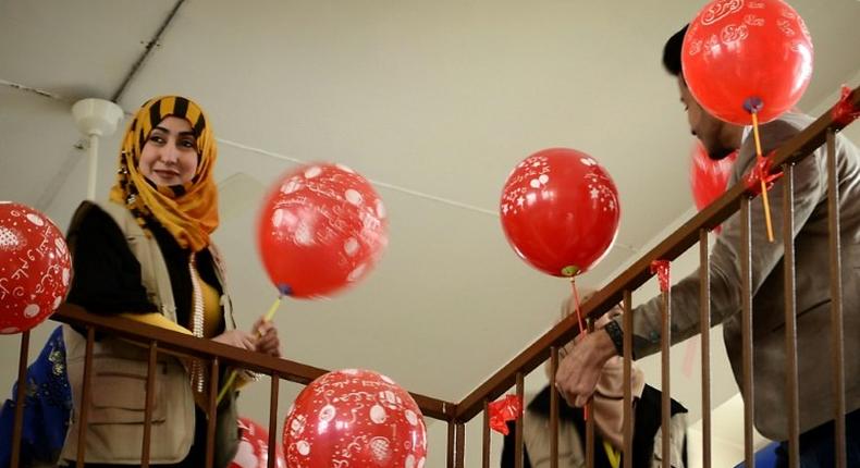 A member from the Rebirth Generation, a group of Iraqi youths who are trying to revive the embattled city of Mosul, distributes balloons as they organise an event to mark Valentine's Day on February 14, 2017