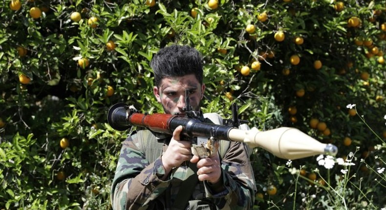 A Hezbollah fighter stands at attention in an orange field near the town of Naqura on the Lebanese-Israeli border on April 20, 2017