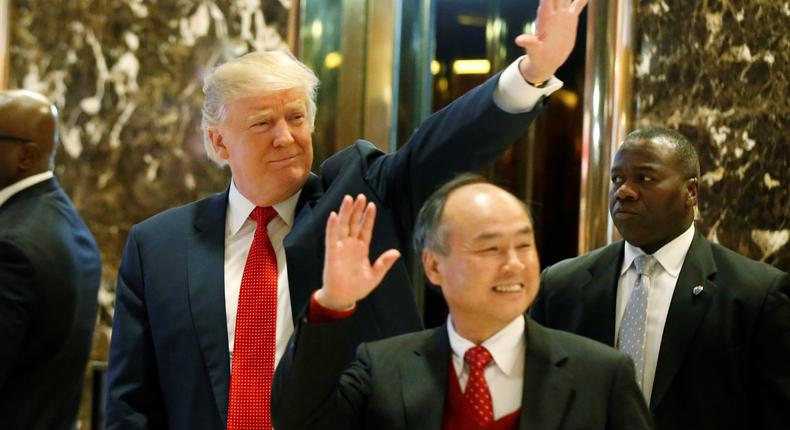US President-elect Donald Trump and Softbank CEO Masayoshi Son acknowledge guests after meeting at Trump Tower.