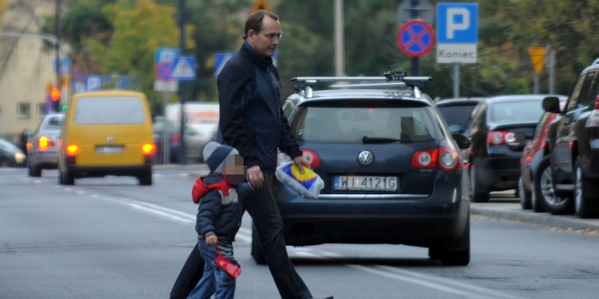 Eugeniusz Kłopotek przeprowadza syna przez ulicę.