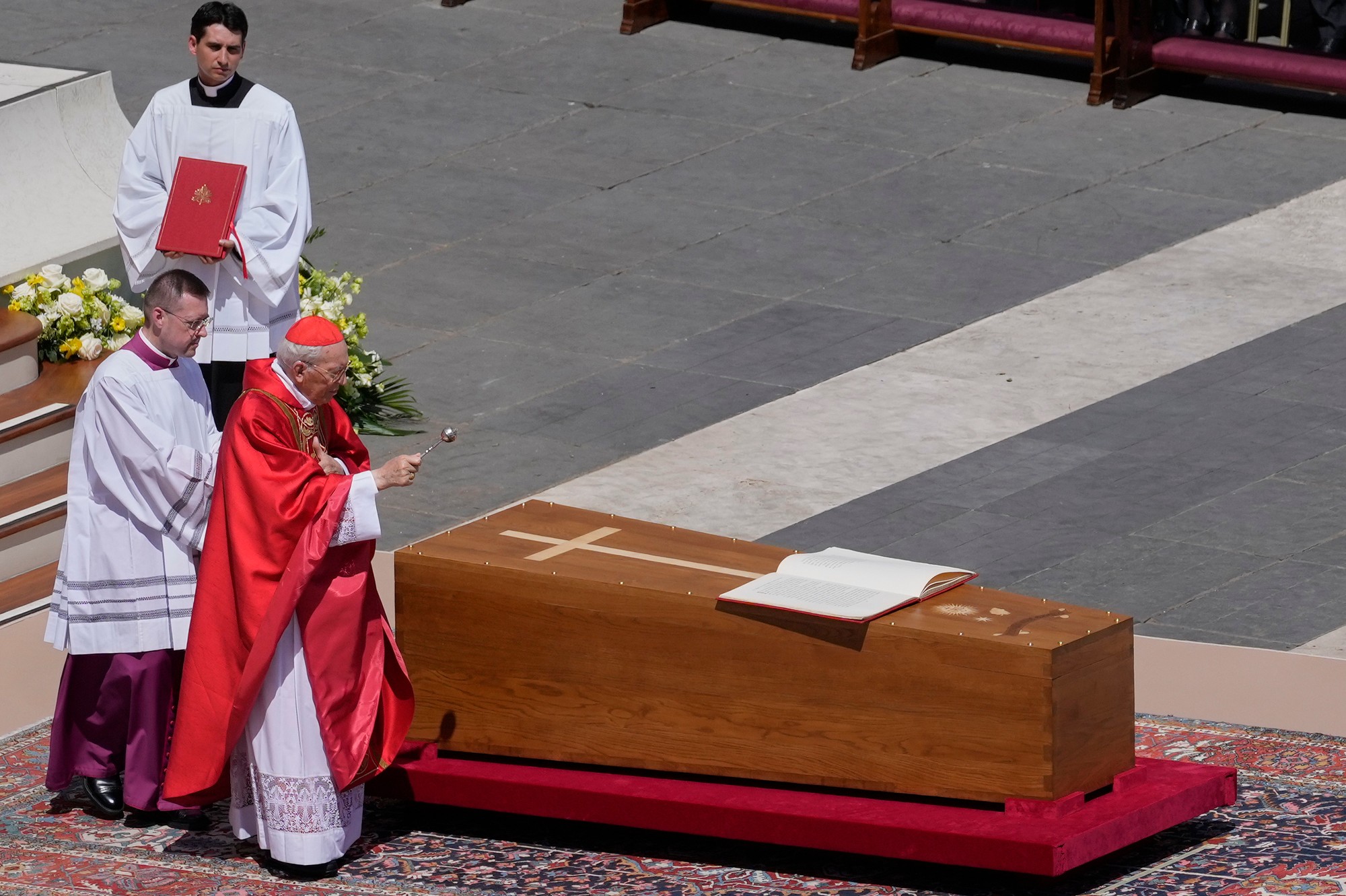 Dekan kolégia kardinálov Giovanni Battista Re požehnáva rakvu pápeža Františka.