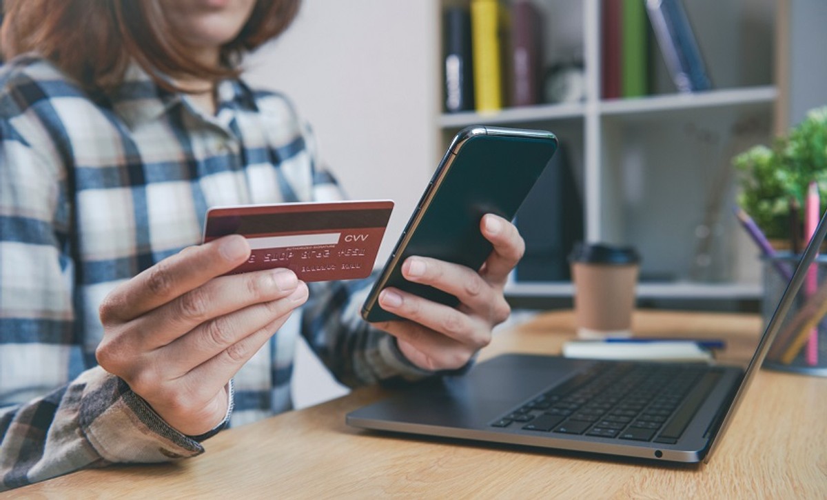 Young woman holding credit card and using smart phone buying online shopping. application mobile banking technology concept.