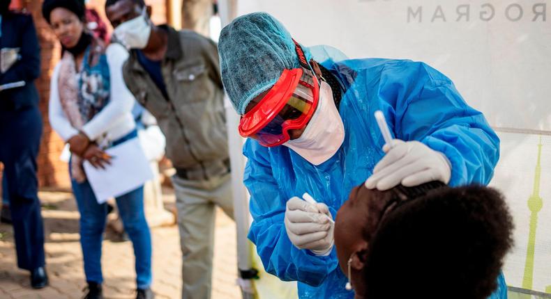 Doctors Without Borders nurse Bhelekazi Mdlalose performs a COVID-19 test on a health worker at the Vlakfontein Clinic in Johannesburg, South Africa, on May 13, 2020.