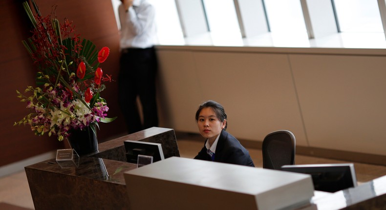 A receptionist sits at a Morgan Stanley office which was visited by Chinese investigators in Shanghai, September 4, 2014. Picture taken September 4, 2014.