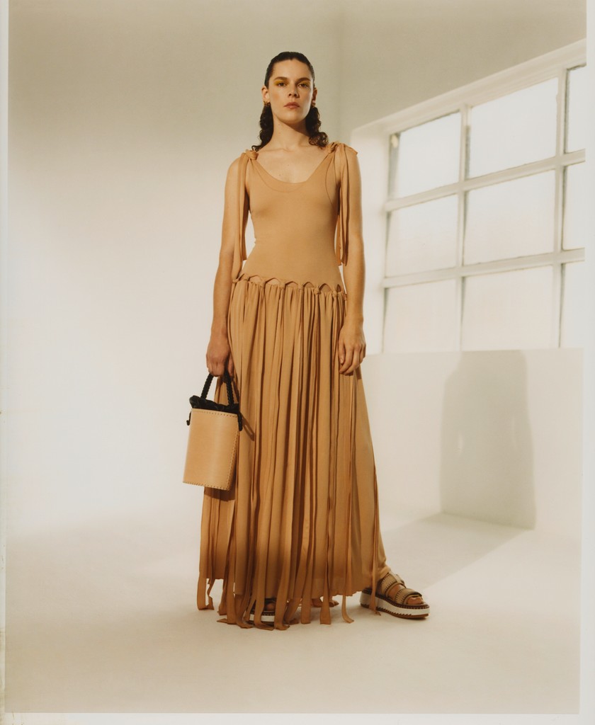 Stretchkleid mit Fransen, Bucket-Bag mit Schulter-riemen und Lederslippers, alles von Chloé.