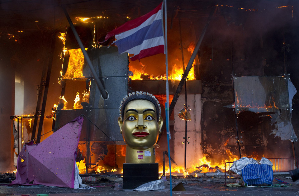 A statue and a torn Thai national flag remain in front of Bangkok's Central World shopping mall, which was gutted by fire after army soldiers advanced towards an encampment of thousands of anti-government "red shirt" protesters, May 19, 2010.