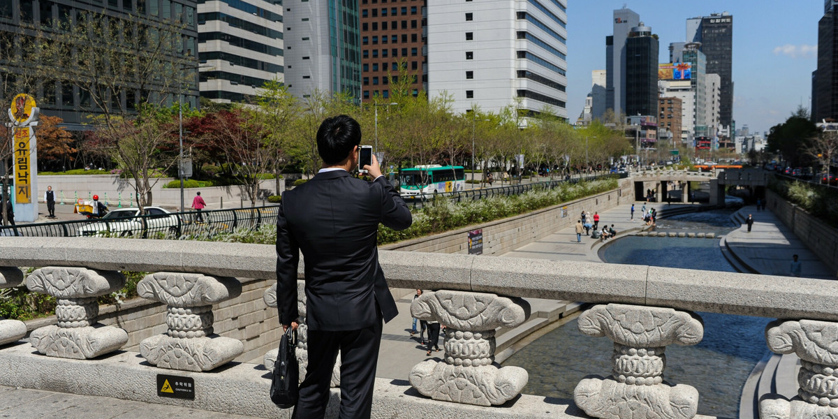 Mężczyzna robi zdjęcie w centrum Seulu.