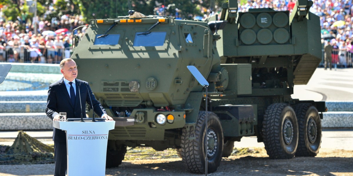 Andrzej Duda przed rozpoczęciem defilady "Silna Biało-Czerwona" z okazji Święta Wojska Polskiego 2023. Za głową państwa wyrzytnia Himars.