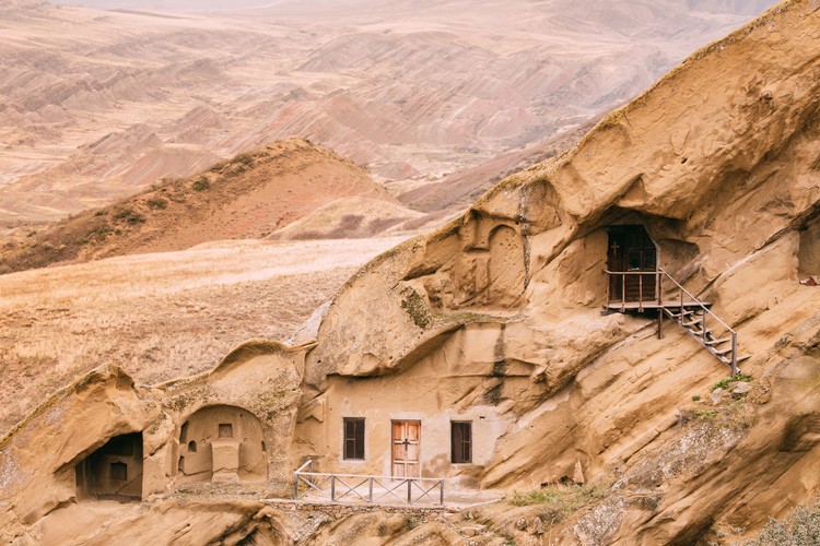 <strong>Tajemnicze jaskinie tworzące miasta</strong>
<br></br>
W Gruzji znajdują się jedne z najbardziej niezwykłych konstrukcji jaskiniowych w Europie. Najstarsze to Uplisciche, wykute w skale miasto, położone zaledwie 10 km na wschód od Gori, na lewym brzegu rzeki Mtkvari. To jedna z najstarszych osad Kaukazu – najstarsze zapiski o Uplisciche pochodzą z VII wieku. Uplisciche i otaczające go zabytki archeologiczne i architektoniczne należą do odrębnej grupy, z której najstarsza pochodzi z wczesnej epoki brązu i uważane są za relikty kultury Kura-Araxes.
<br></br>
Warto zobaczyć także Davit Gareja, rozległy klasztorny kompleks wykuty w skale góry Gareja. Jaskinie mieściły kiedyś prawie 5000 mnichów. Jedna z nich nadal funkcjonuje jako klasztor, czasem można nawet usłyszeć śpiewy rozchodzące się w ciszy opuszczonego stepu. Kompleks 19 klasztorów uważany jest za arcydzieło sztuki gruzińskiej.   
<br></br>
Nie sposób nie wspomnieć także o Vardzia, spektakularnym podziemnym kompleksie, w którym mieszkało niegdyś 2000 mnichów. Zbudowany został on w XII wieku, pod panowaniem Tamar, pierwszej kobiety, która została koronowana na króla. Wykuty w skale klasztor-forteca rozciąga się na długości ponad 500 metrów i liczy aż 600 pokoi. Znajduje się w historycznym regionie Samtskhe-Javakheti. Obiekt wpisany jest na listę światowego dziedzictwa kultury UNESCO, jako jedno z najbardziej unikatowych miast skalnych na świecie.
<br></br>