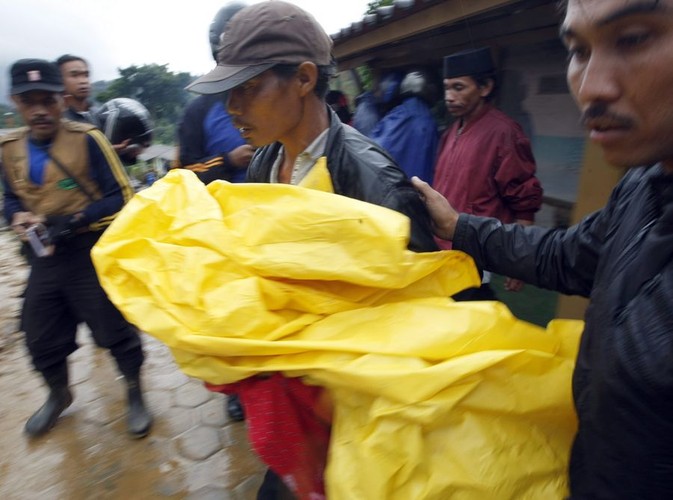 Ponad 70 osób zginęło w osunięciach ziemi i lawinach błotnych na indonezyjskiej Jawie. Na zdjęciu: ojciec niesie ciało martwego syna