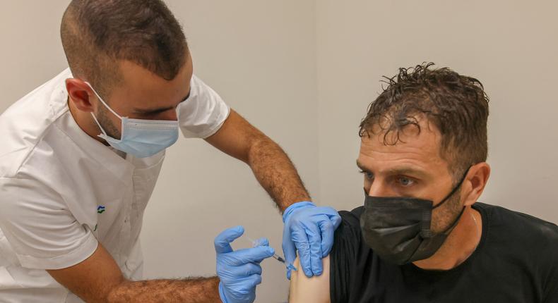 A health worker administers a dose of the Pfizer vaccine in the Palestinian neighborhood of Beit Hanina, on August 29, 2021.
