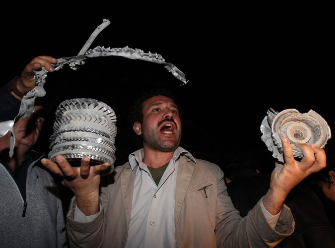 Libijczycy na gruzach budynku w Trypolisie, należącego do administracji Muammara Kadafiego, położonego zaledwie 50 metrów od namiotu, w którym Kadafi przyjmuje gości