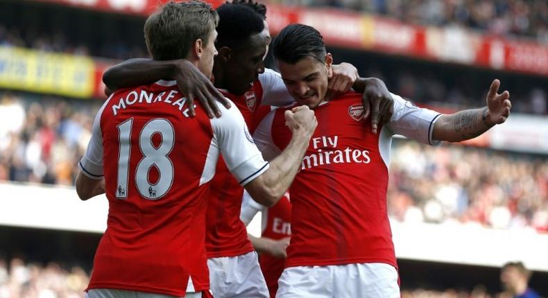 Arsenal players celebrate after scoring the opening goal of the English Premier League football match against Manchester United in London on May 7, 2017