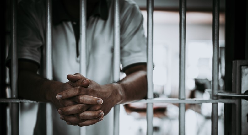 Midsection Of Man Standing In Prison - stock photoKittirat Roekburi / Getty Images