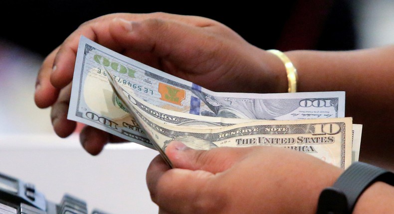 FILE PHOTO: A cashier handles money in Macy's Herald Square in Manhattan, New York, U.S., November 23, 2017.  REUTERS/Andrew Kelly