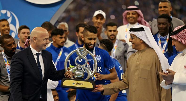 FIFA President Gianni Infantino (left) presents the trophy to Al Hilal midfielder Salman Al-Faraj Creator: Fayez Nureldine