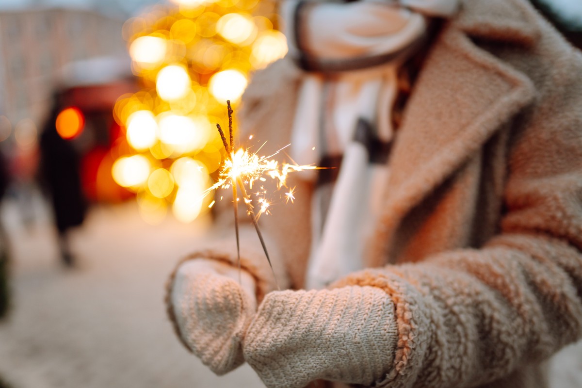 Burning,Sparklers,In,Woman's,Hands.,Winter,Holidays.,Young,Smiling,Woman