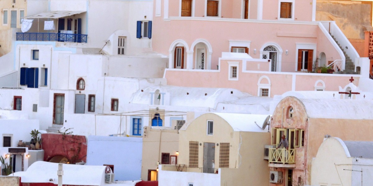 Man watches the sun set on the Greek island of Santorini, Greece