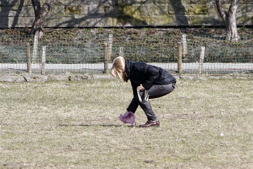 Torbicka sprząta po psie. Foto