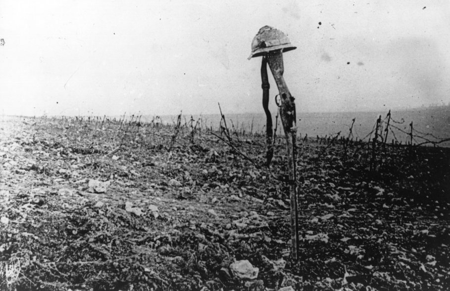 Grób francuskiego żołnierza oznaczony jego karabinem i hełmem na polu bitwy pod Verdun, 1916 r.