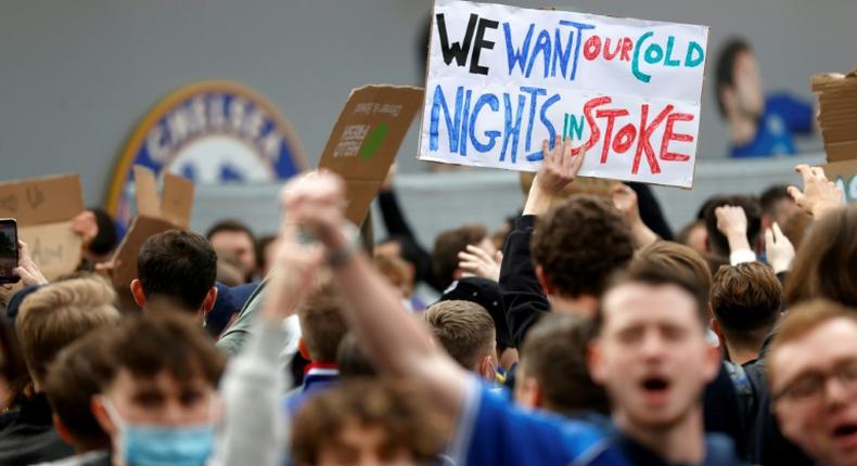 Football supporters hold placards as they demonstrate against the proposed European Super League