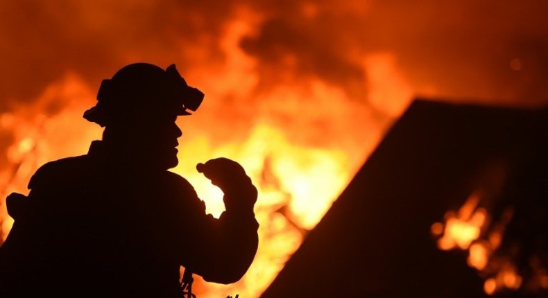 A firefighter drinks water in front of a burning house near Oroville, California on July 9, 2017. Crews are battling the season's first major wildfires since the state's five-year drought ended earlier this year