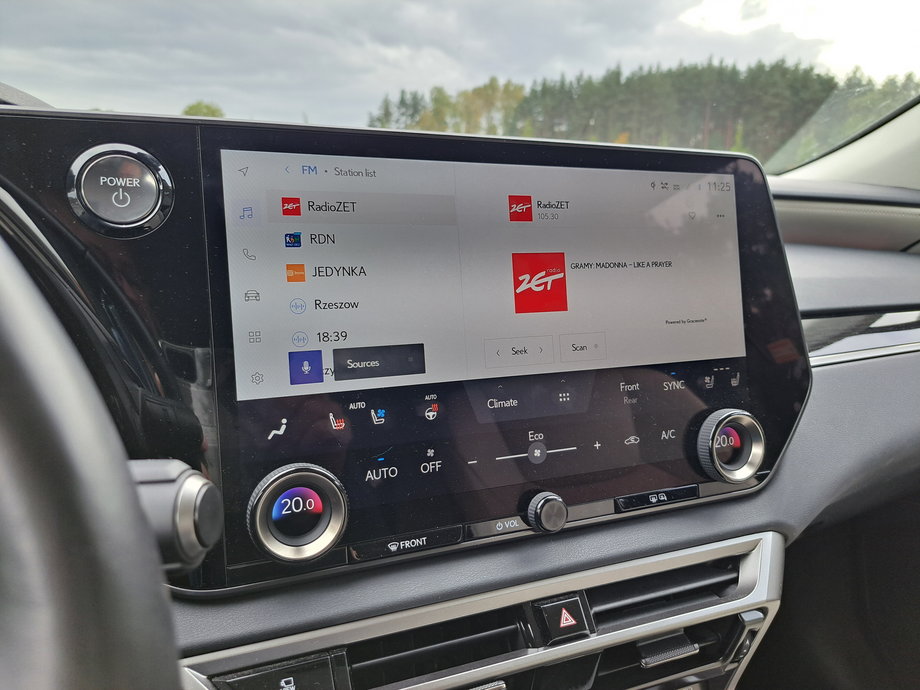 Lexus RX 450h+ - na środkowej konsoli mamy ogromny ekran systemu multimedialnego. Ale klimatyzacją można sterować za pomocą pokręteł i wirtualnych (ale stałych) przycisków.
