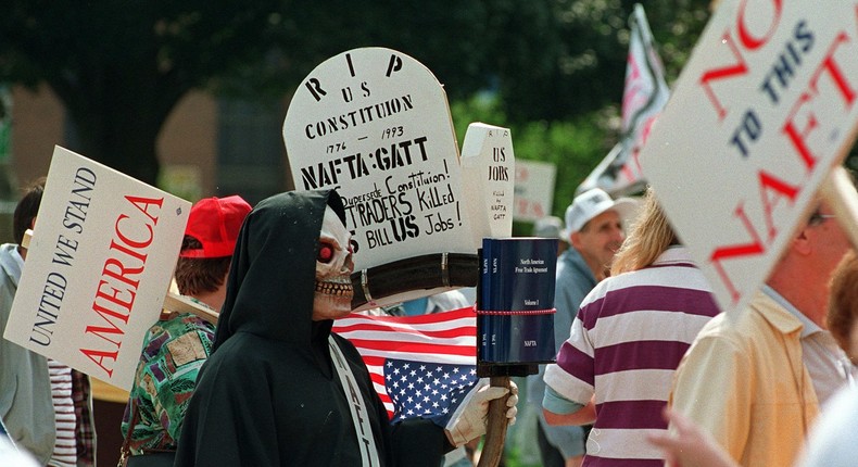 A man calling himself The Death of US Jobs joins thousands of other people as they attend the Not To This NAFTA rally on the steps of the state capitol in Lansing, Michigan, September 18, 1993.