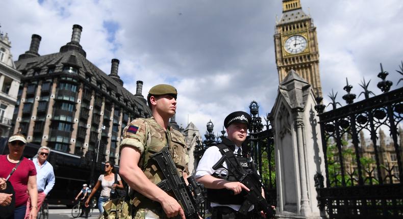 An armed soldier and an armed police officer patrol outside the Houses of Parliament on May 24, 2017 in London, England.