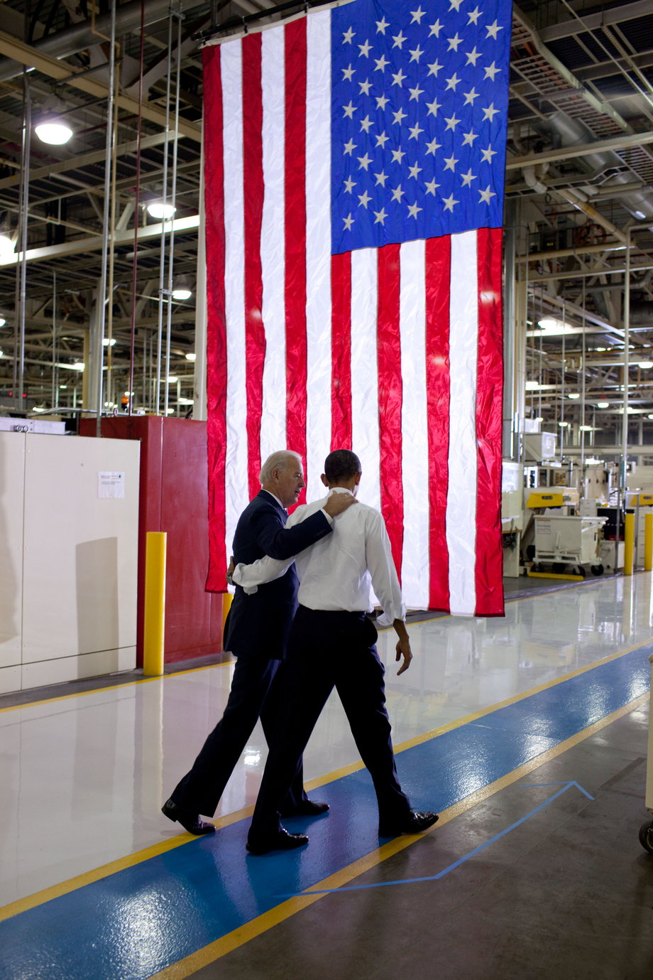 Obama and Biden walk arm and arm before speaking at the Chrysler Transmission Plant.