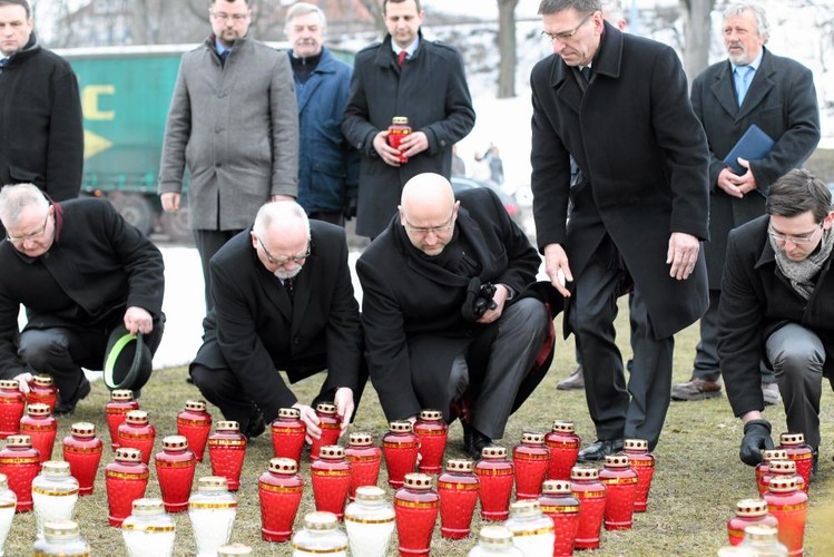 Rondo Ofiar Katastrofy Smoleńskiej. Urzędnicy [radny PIS Leszek Araszkiewicz, radny Ponad Podziałami Marian Zdunek, przewodniczący rady miejskiej Jan Tandyrak (PO) , prezydent Piotr Grzymowicz [z asystentem]. składają znicze w 3. rocznicę katastrofy samolotu prezydenckiego pod Smoleńskiem