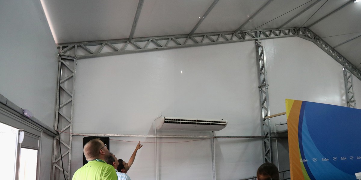 Staff look at a bullet hole inside the media center at the Olympic Equestrian Centre.