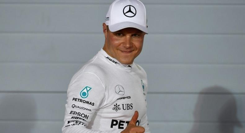 Mercedes' Finnish driver Valtteri Bottas celebrates after taking the pole position at the end of the qualifying for the Bahrain Formula One Grand Prix at the Sakhir circuit in Manama on April 15, 2017