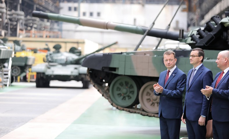 Mariusz Błaszczak (pierwszy z lewej) i Mateusz Morawiecki (w środku) podczas uroczystości podpisania umowy na remont czołgów T-72 z modyfikacją w Zakładach Mechanicznych Bumar-Łabędy (22.07.2019) 